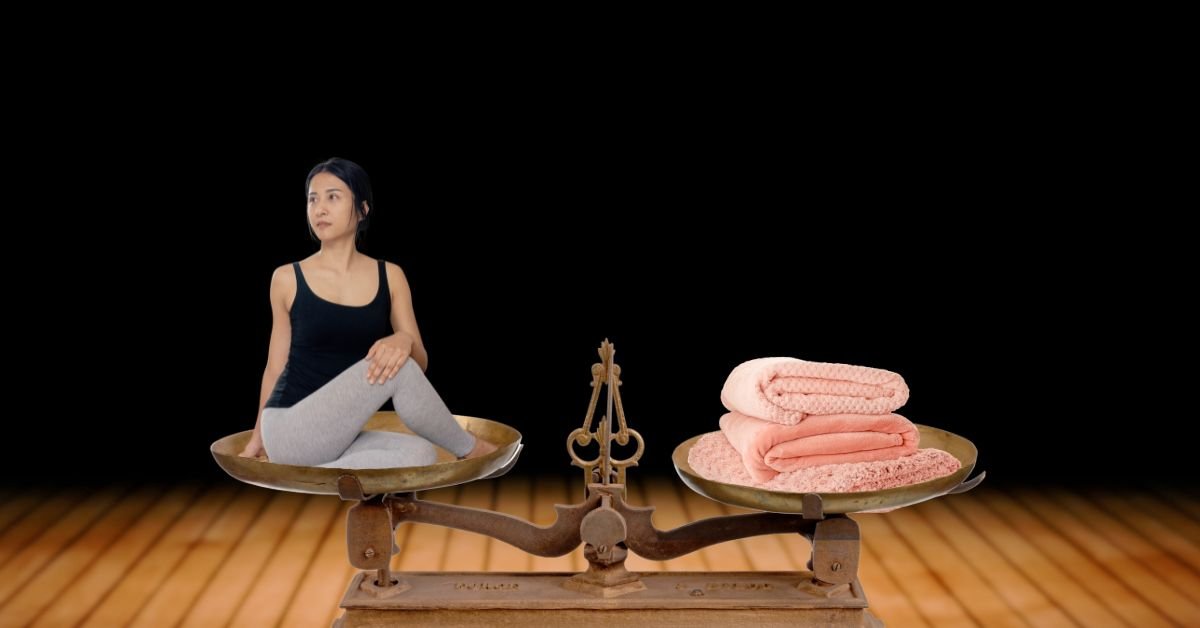 A woman sitting on one side of a balance scale with weighted blankets on the other side